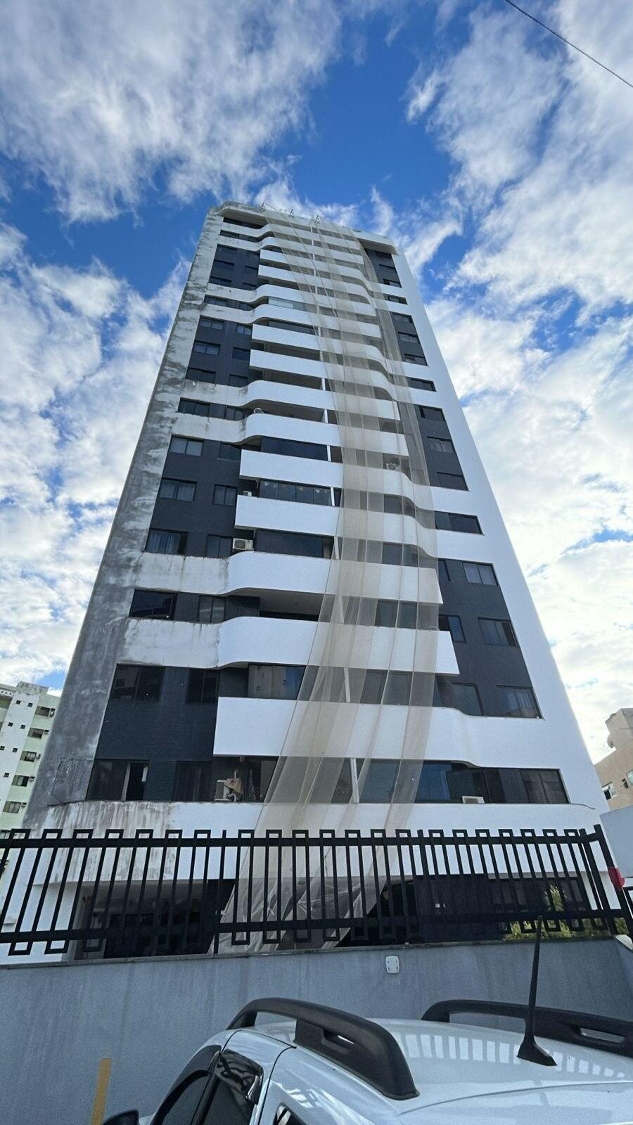 Fachada frontal do Recanto das Gaivotas durante a fase final de recuperação e pintura, com tela de proteção ainda instalada.