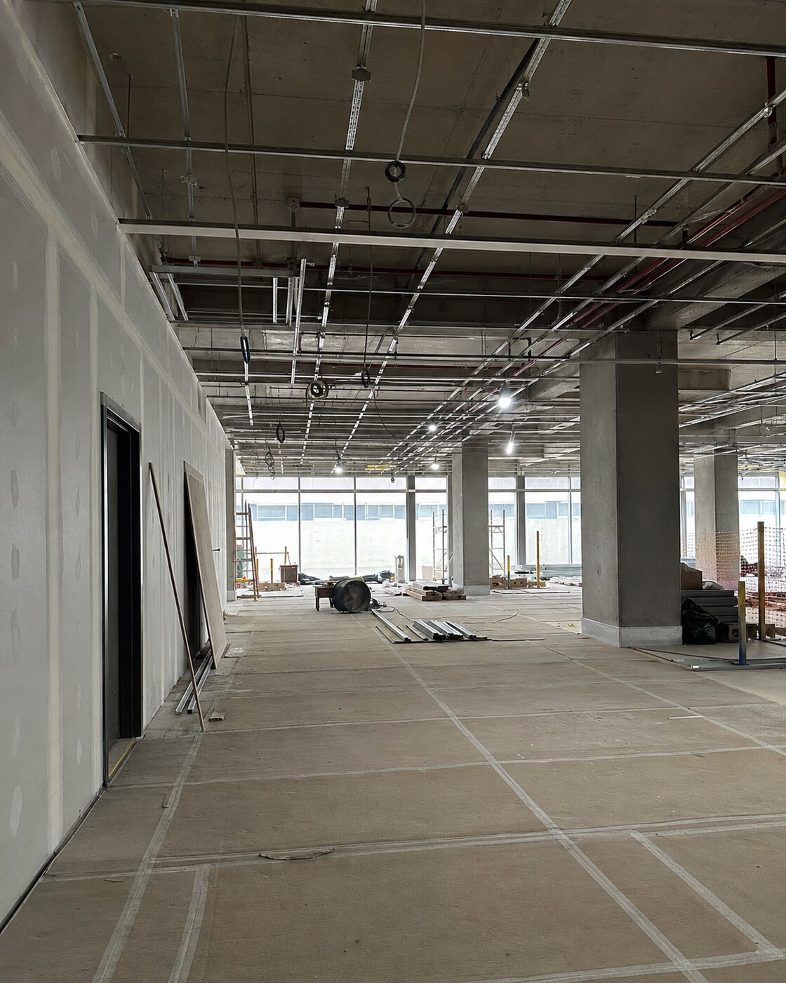 Visualização de uma obra comercial interna em fase de instalações e acabamentos.